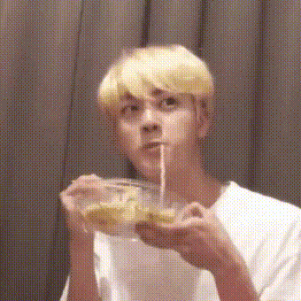 Gif of seokjin eating noodles awkwardly during that one 'eat with emotion' vlive when Namjoon comes in.